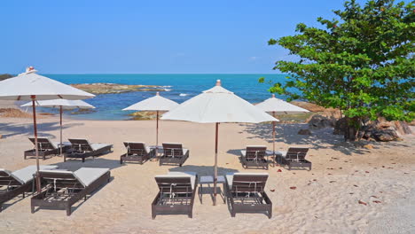 White-sand-beach-with-free-comfortable-lounges-and-white-umbrellas-near-the-ocean-or-sea-during-bright-sunny-day