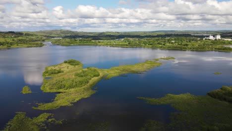 Panoramic-aerial-footage-over-river-and-green-hills-during-high-tide,-the-Gearagh-protected-nature-in-county-Cork,-Ireland