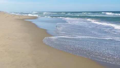 Beautiful-sunny-day-on-a-calm-pristine-beach-with-blue-skies-in-North-Carolina-in-the-Outer-Banks-in-Nags-Head-during-early-summer