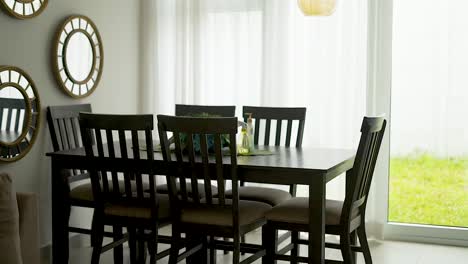 Esszimmer-Mit-Tisch,-Stühlen-Und-Spiegeln-Neben-Einem-Fenster