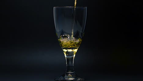 Pouring-gold-liquid-into-glass-in-slow-motion