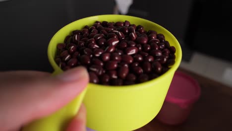 closeup-shot-of-red-beans-being-poured-from-bowl-whilst-making-Bubur-Kacang-Merah