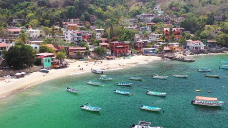 Aerial-view-of-boats-and-colourful-houses-of-coasline-in-Yelapa-town-in-Cabo-Corrientes,-Jalisco,-Mexico