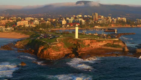 Aerial-View-Of-Flagstaff-Point-Lighthouse-With-Cityscape-In-Background-During-Sunset-In-Wollongong,-New-South-Wales,-Australia---drone-shot