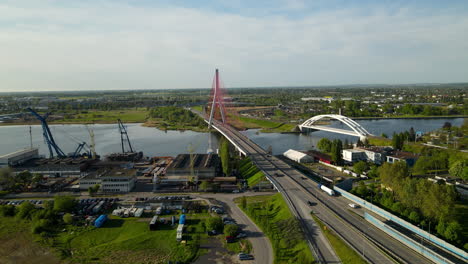 Traffic-On-Bridge-Over-Martwa-Wisla-River-With-Harbor-Crane-On-Riverbank-In-Gdansk,-Poland