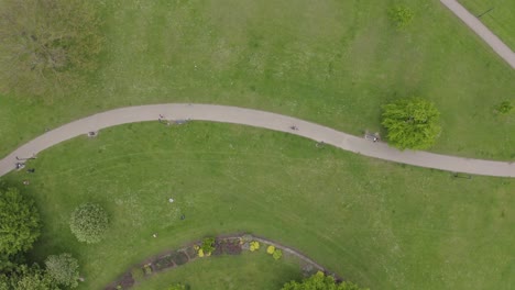 Top-down-birds-eye-view-aerial-shot-of-people-and-cyclists-in-a-park-in-summer