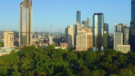 Aerial-view-of-Brisbane-City-CBD-behind-Botanical-Gardens-and-Queen's-Wharf-construction-site-Cranes-visible,-QLD,-Australia