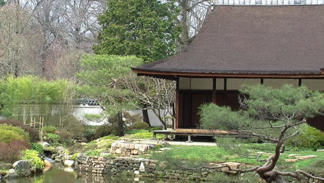 Ecke-Eines-Japanischen-Hauses-Mit-Steinmauern,-Die-Einen-Teich-Umranden