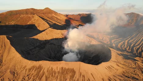 Volcanic-landscape-illuminated-by-golden-sunshine-during-sunrise,-Mount-Bromo