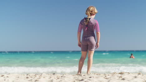 Little-girl-standing-relaxed-on-the-beach-by-the-sea