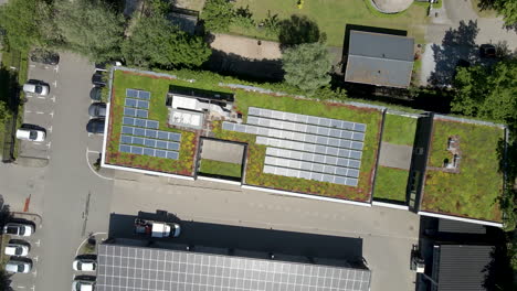 Top-down-aerial-of-solar-panels-on-a-green-rooftop---drone-setting-down
