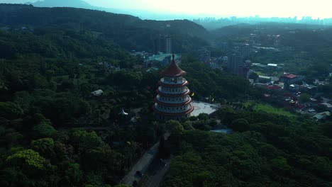 Aerial-view-showing-Temple-Tianyuan-in-Tamshui-city-surrounded-by-green-forest-trees-in-Taiwan