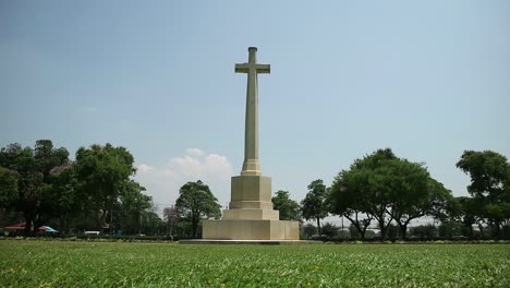 HD-statische-Aufnahme-Des-Gedenkfriedhofs-Des-Zweiten-Weltkriegs-Mit-Hohem-Kruzifix-Denkmal-Auf-Einem-Friedlichen-Friedhof-In-Kanchanaburi,-Thailand