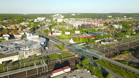 Aerial-View-Of-Traffic-on-Truss-Bridge-Over-Multilane-Railroad-Of-Trains-and-Complicated-Roads-Intersection-In-city-center-of-Gdansk,-Poland,-slow-orbit-flight-around