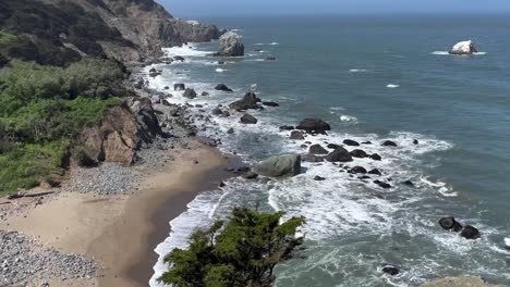 Dolly-Tilt-Shot-of-the-Rugged-Pacific-Coast-and-Strong-Pacific-Ocean-on-a-Bright-Sunny-Day-in-San-Francisco,-California
