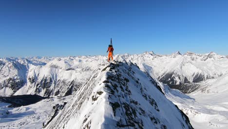 Junger-Männlicher-Bergsteiger,-Der-Im-Winter-Mit-Viel-Neuschnee-Einen-Gipfel-Mit-Skiern-Erklimmt