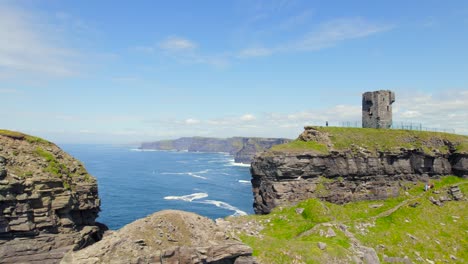 Aerial-reveal-footage-of-Cliffs-of-Moher-from-behind-a-rock-where-Moher-Tower-is-located