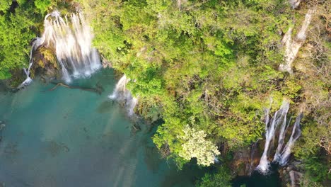 DRONE-view-of-Tamasopo-waterfalls-surrounded-by-trees-in-San-Luis-Potosi,-Mexico