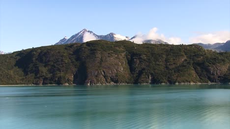 Turquoise-waters-of-Tarr-Inlet-from-Alaska,-Snowy-mountains-in-the-background
