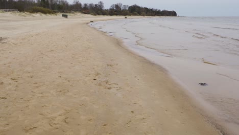 Walking-alongside-Baltic-sea-sandy-coastline-on-moody-day