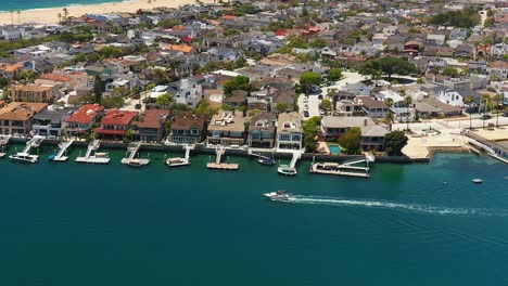 Aerial-view-of-a-boat-in-the-channel-off-of-Balboa-island,-in-Newport-Beach,-California