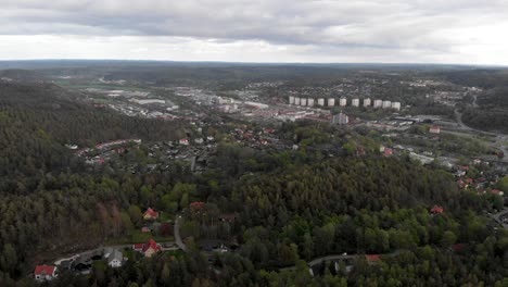 Partille-Municipality-in-Sweden-between-vast-vibrant-green-forests,-aerial-dolly-in