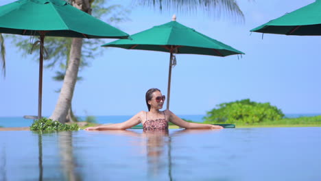 Asiatische-Frau-Im-Pool-Mit-Meer-Im-Hintergrund-Entspannen