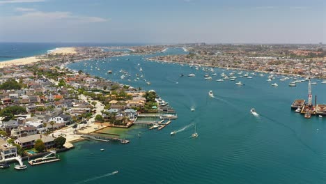 Aerial-view-of-boats-navigating-the-channel-in-Newport-Beach,-California