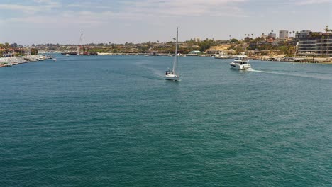 Aerial-view-of-a-sailboat-in-the-Newport-Beach-channel,-California