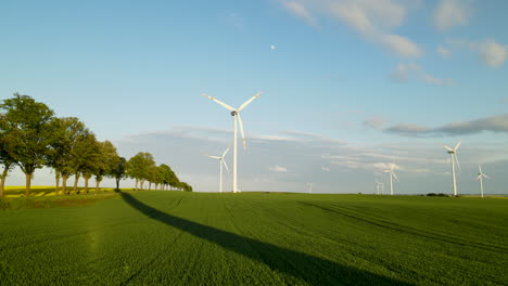 Parque-Eólico-En-Lebcz,-Puck,-Polonia---Turbinas-Eólicas-Que-Generan-Energía-Limpia-En-El-Campo-Con-árboles-Y-Cultivos-Verdes
