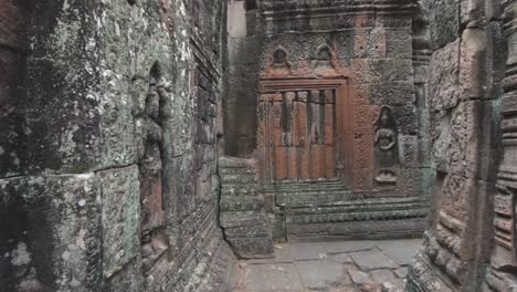 Visitor-walking-point-of-view-of-Angkor-temple-carved-walls-details