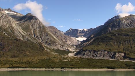 Kleine-Wolken-über-Den-Gipfeln-Der-Berge-Und-Der-Rest-Eines-Gletschers,-Landschaft-Von-Alaska