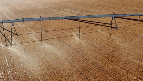 Irrigation-nozzles-spray-water-mist-on-brown-field
