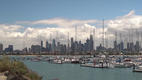 Static-wide-shot-showing-marina-with-docking-sailing-boats-and-Skyline-of-Melbourne-in-background,Australia