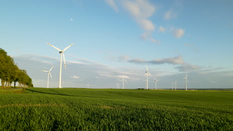 Turbinas-De-Viento-Girando-Con-Cultivos-Verdes-En-El-Campo-De-Cultivo-De-Lebcz,-Puck,-Polonia