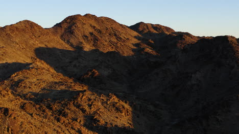 Sunny-Day-Cast-Shadow-Over-Mountains-At-Red-Cloud-Mine,-Arizona,-USA,-Aerial