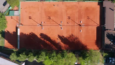 Top-View-Of-People-Playing-Tennis-At-An-Outdoor-Tennis-Court-In-Novi-Sad,-Serbia-On-A-Sunny-Morning