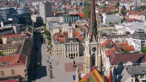 Uhrturm-Der-Namenskirche-Der-Mary-In-Novi-Sad,-Serbien-Mit-Blick-Auf-Das-Denkmal-Von-Svetozar-Miletic-Auf-Dem-Platz-Der-Freiheit