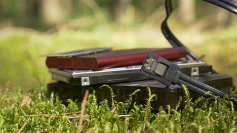 slide-shot-of-external-and-internal-hard-drives-and-ssd-on-the-moss-in-the-forest