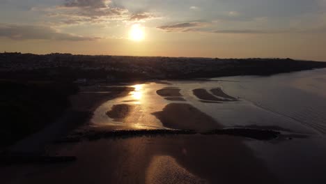 Goldene-Himmlische-Sonnenuntergänge-Strahlen-Luftbild-Reflektiert-über-Romantisch-Beleuchtete-Strandküste
