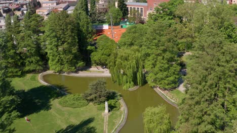 Aerial-shot-descending-and-circling-around-Danube-Park-in-Novi-Sad,-Serbia-on-a-sunny-day