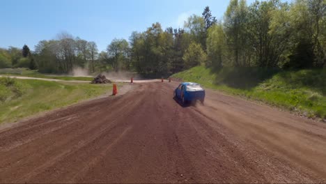 Rally-car-with-Swedish-flag-speeding-on-a-dirt-road