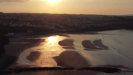 Goldene-Himmlische-Sonnenuntergangsstrahlen-Luftaufnahme-Reflektiert-über-Romantischen-Exotischen-Strand-Küstenlinie-Hoher-Winkel-Rechter-Dolly
