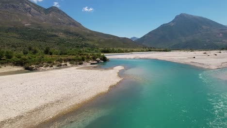 Turquoise-water-of-Vjosa-river-streaming-from-wilderness-mountains-on-natural-environment,-Albania