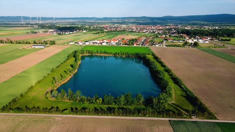 AERIAL---Lake-reservoir-next-to-Deutsch-Brodersdorf,-Austria,-wide-shot-forward