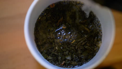Nahaufnahme-Des-Gießens-Von-Kochendem-Wasser-In-Eine-Tasse-Grünen-Tee,-Gesundes-Getränk-Aus-Asien