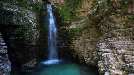 Filmaufnahme-Eines-Wasserfalls-In-Einem-Schluchtloch-Mit-Felsigen-Hängen-In-Albanien