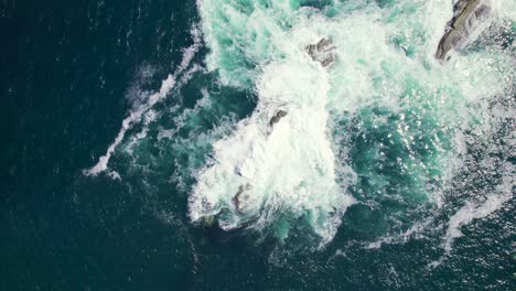 Aerial-view-of-a-sea-rock-with-water-splashing