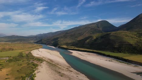 Río-Esmeralda-Vjosa-En-Albania-Fluyendo-Hacia-El-Valle-Con-Montañas-Y-Fondo-De-Cielo-Azul