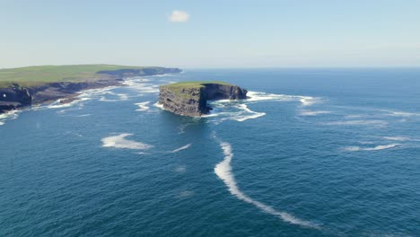 Aerial-Spin-around-Illaunonearaun-Natural-Heritage-Area-islet-with-Kilkee-Cliffs-in-the-background